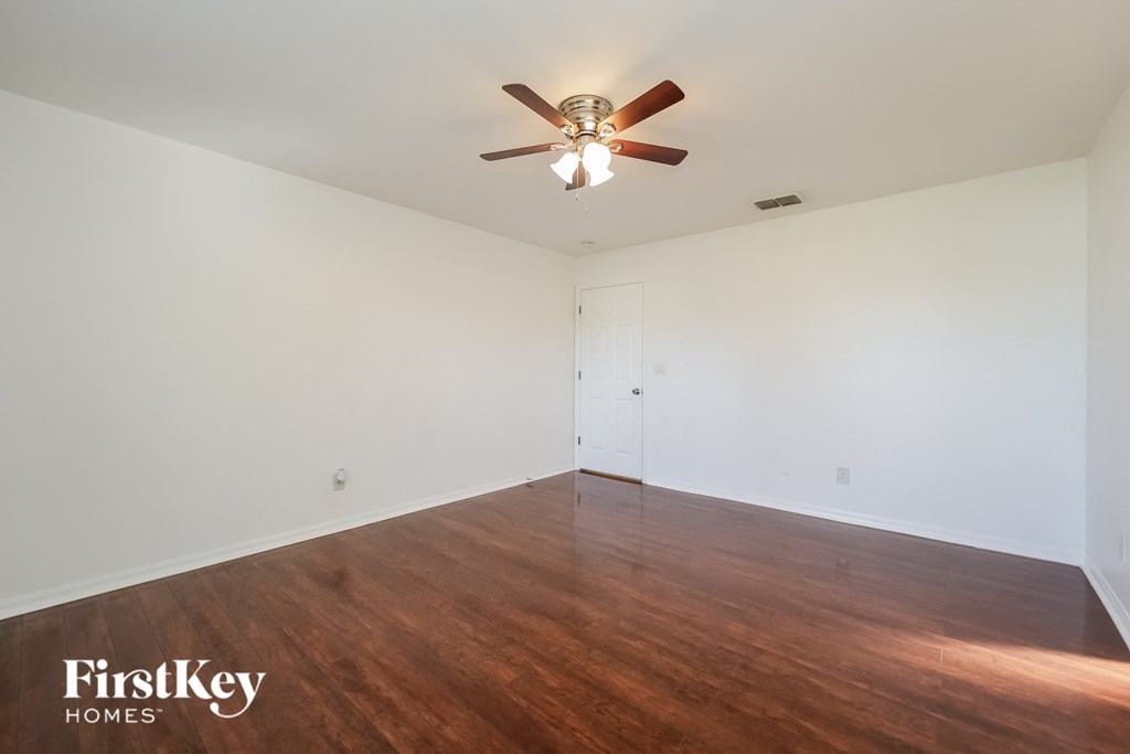 a living room with wood floors and a ceiling fan