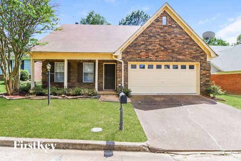 a small brick house with a white garage door