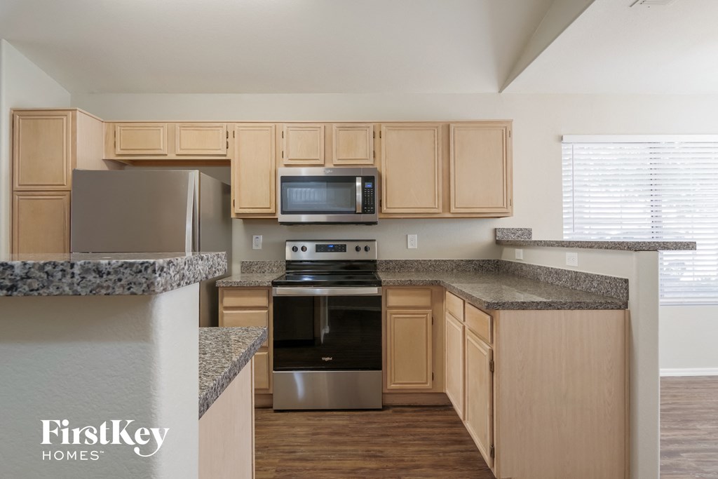 a kitchen with granite counter tops and wooden cabinets