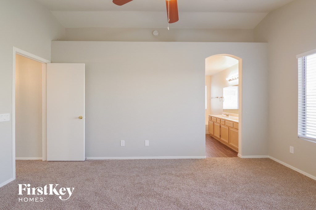 a bedroom with a carpeted floor and a door to a bathroom