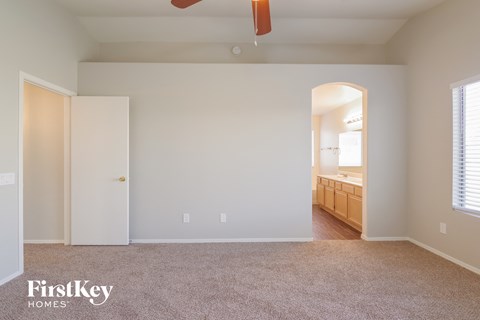 a bedroom with a carpeted floor and a door to a bathroom