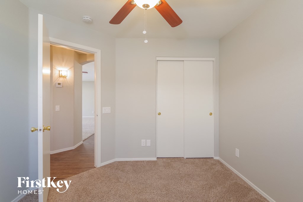 a bedroom with a ceiling fan and a closet