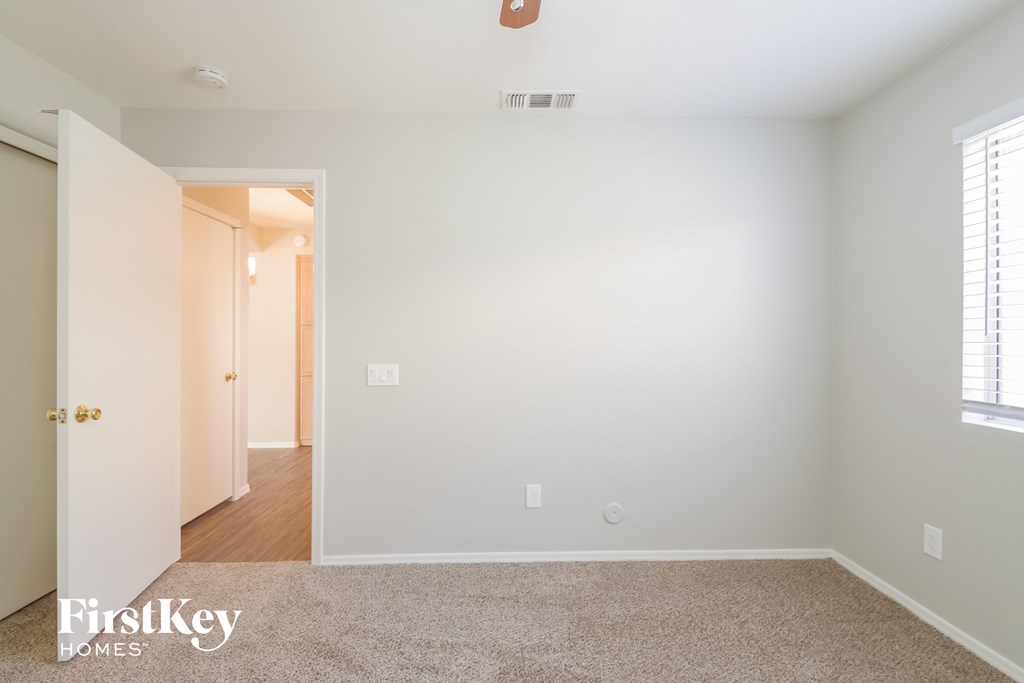 a bedroom with a carpeted floor and a door to a hallway