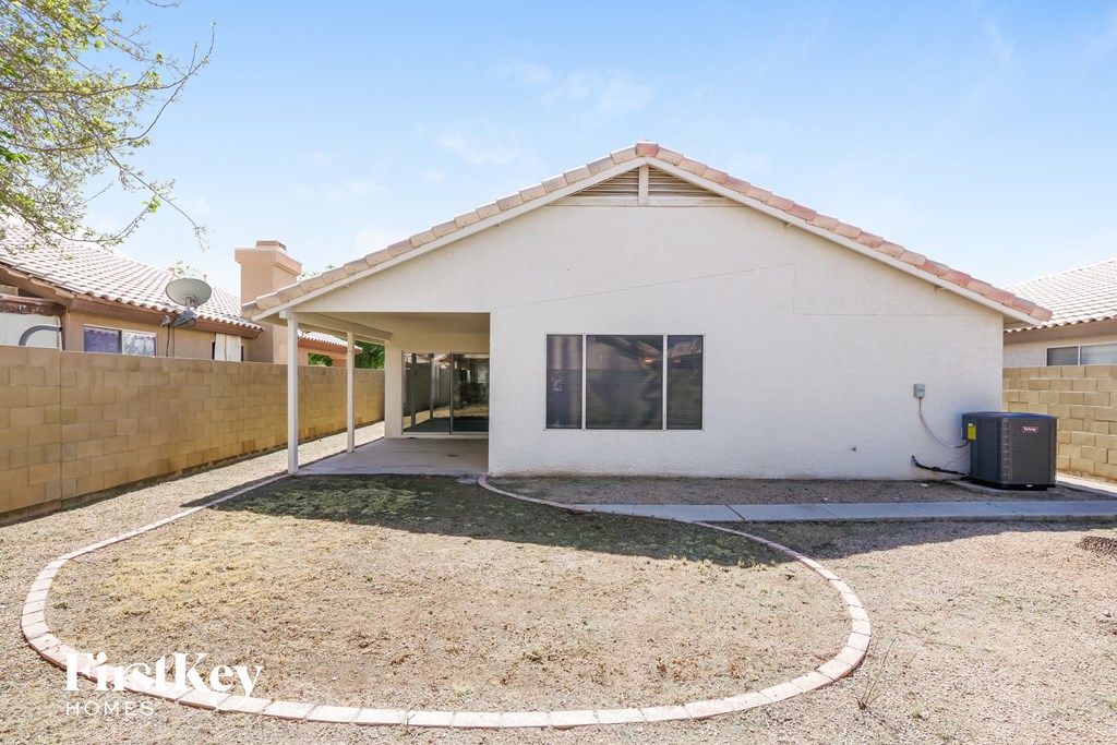 a small white house with a yard and a driveway