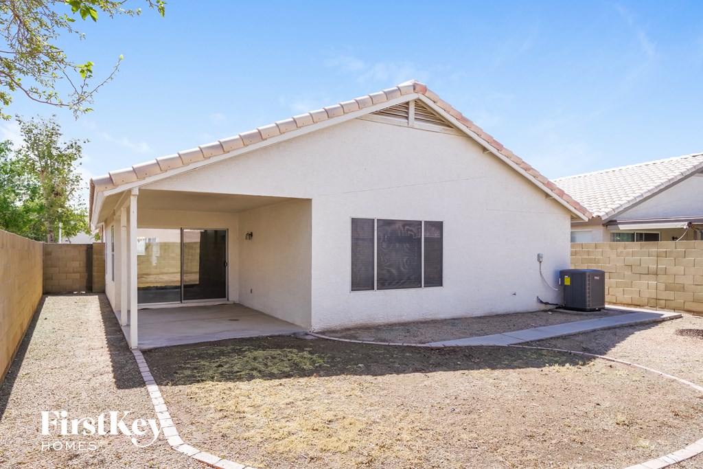 a small white house with a yard and a driveway