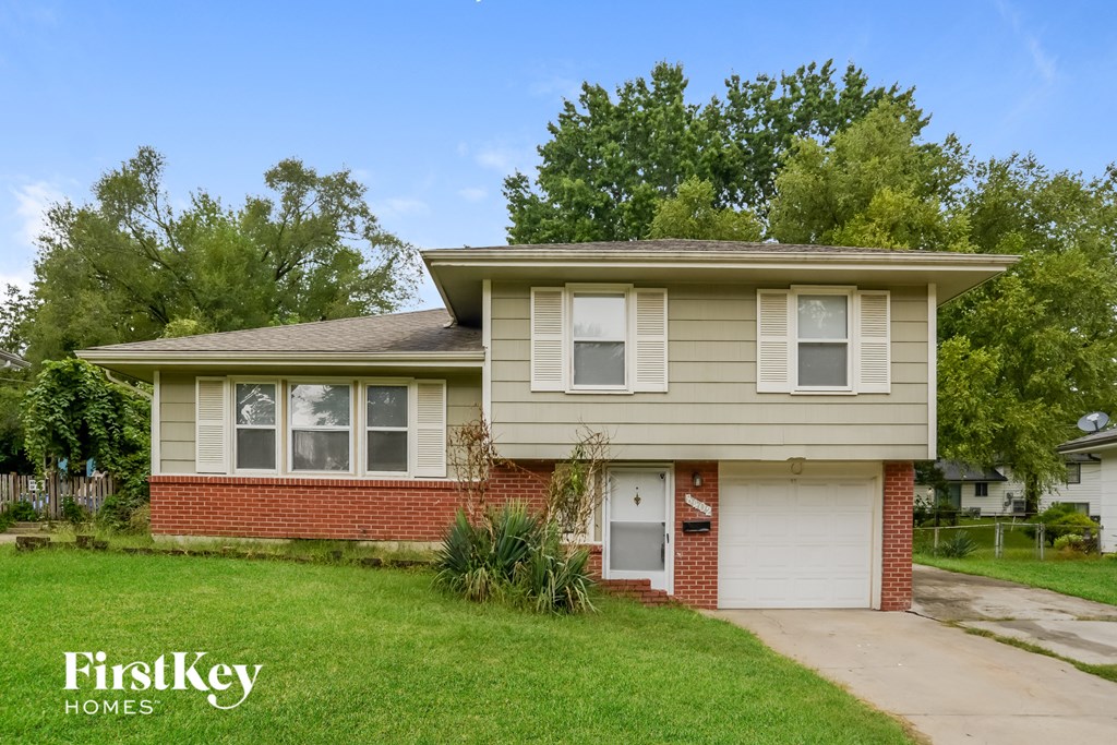 a small brick house with a white door and a lawn