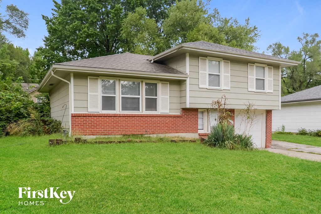 the front of a house with a lawn and a sidewalk