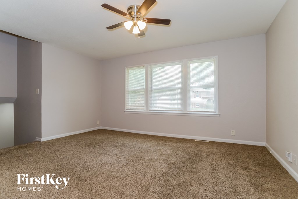 a bedroom with a carpeted floor and a ceiling fan