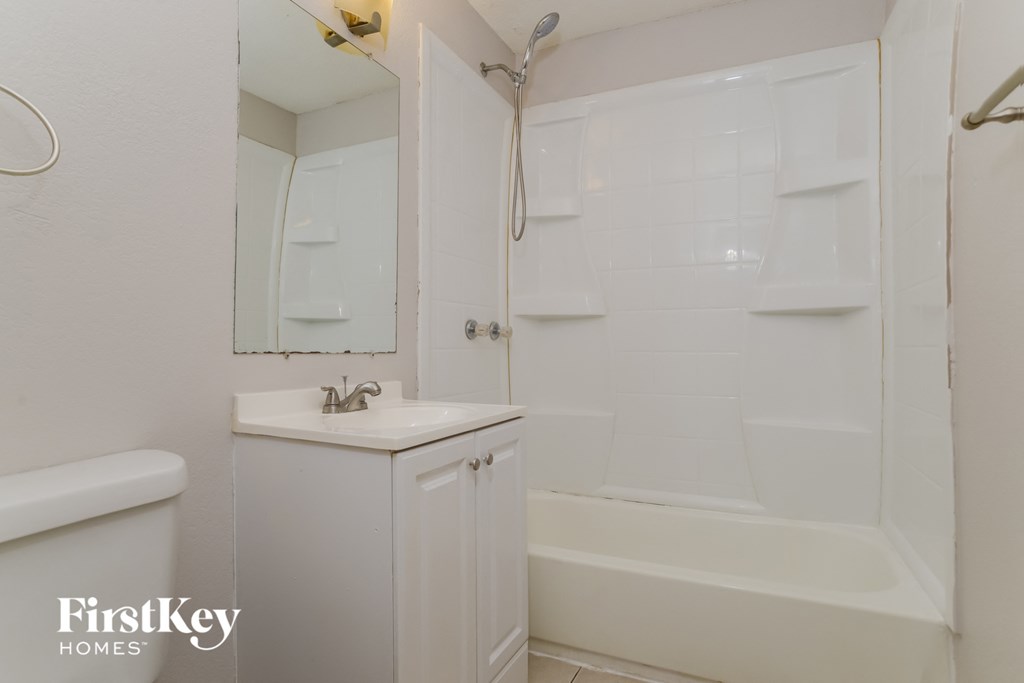 a white bathroom with a shower and a sink and a tub