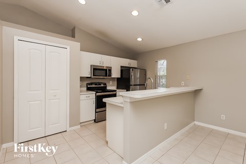 A kitchen with a white counter and appliances.