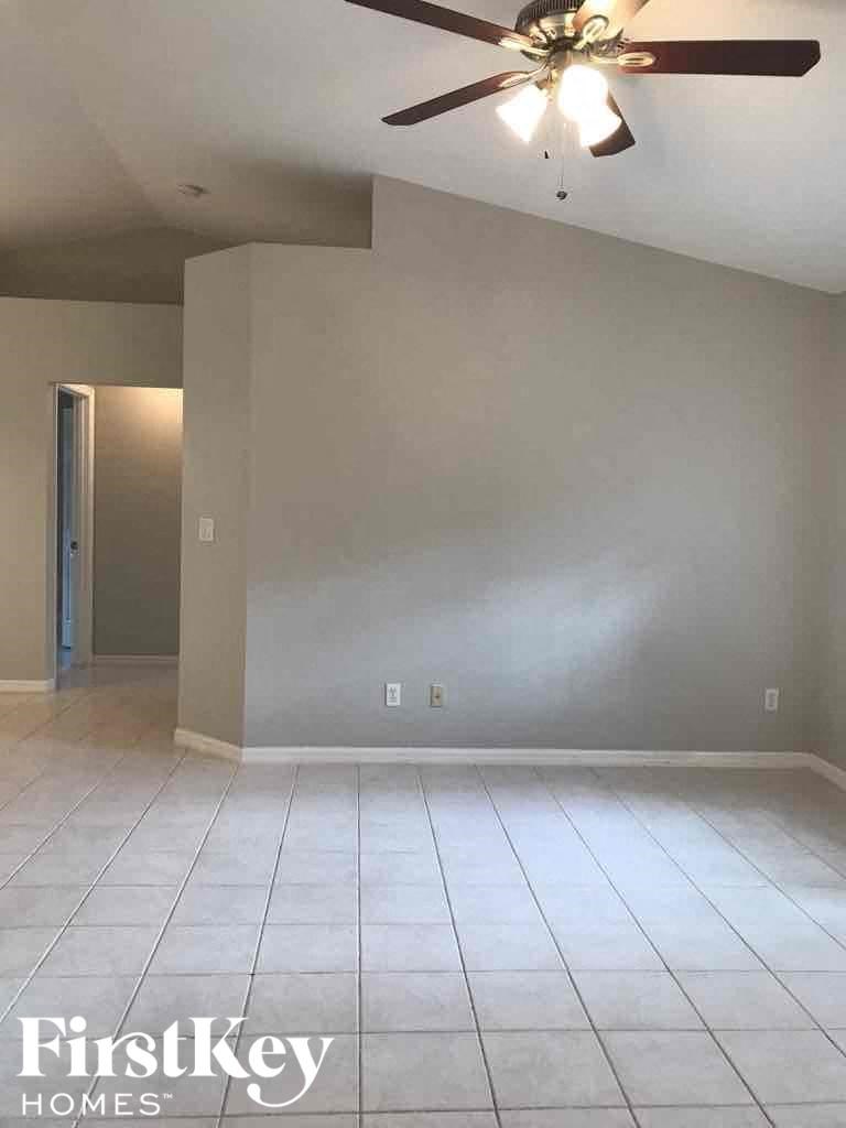 A room with a ceiling fan and tile flooring.