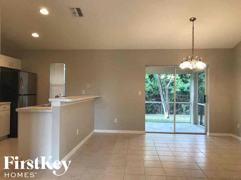 A spacious kitchen and living room with a sliding glass door leading to a backyard.