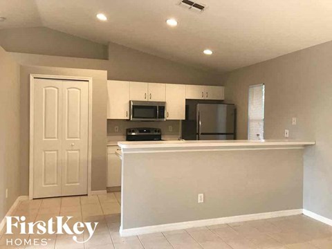 A kitchen with a white counter and cabinets.