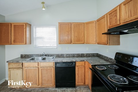 A kitchen with wooden cabinets and black appliances.