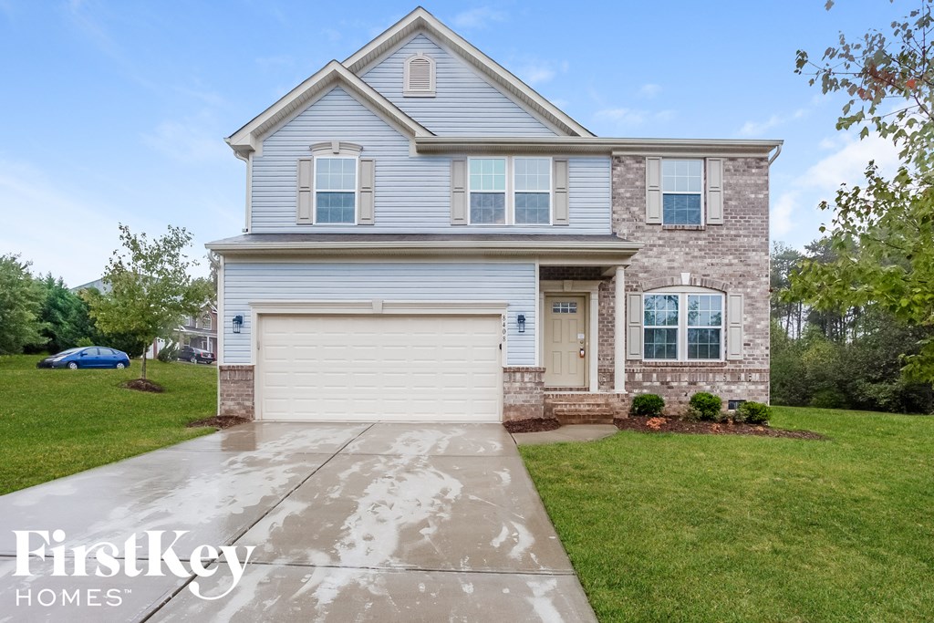 a home with a white garage door and a brick house