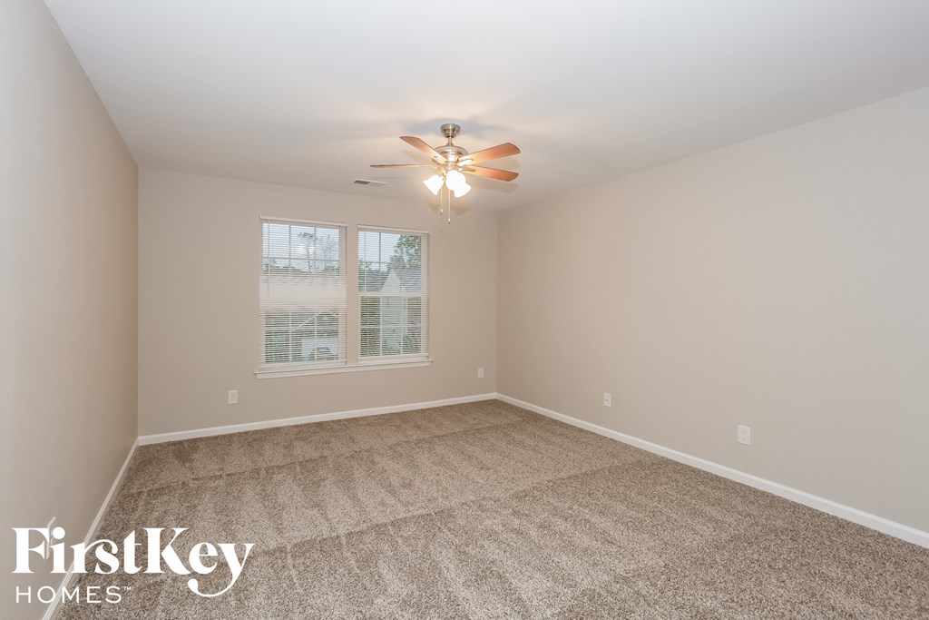 a bedroom with a carpeted floor and a ceiling fan