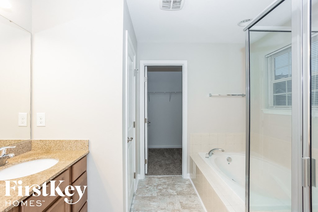 a bathroom with a tub and a shower and a sink