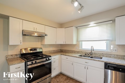 A kitchen with a stove top oven and a sink.