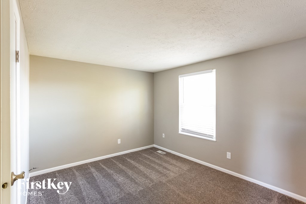 an empty room with carpet and a window