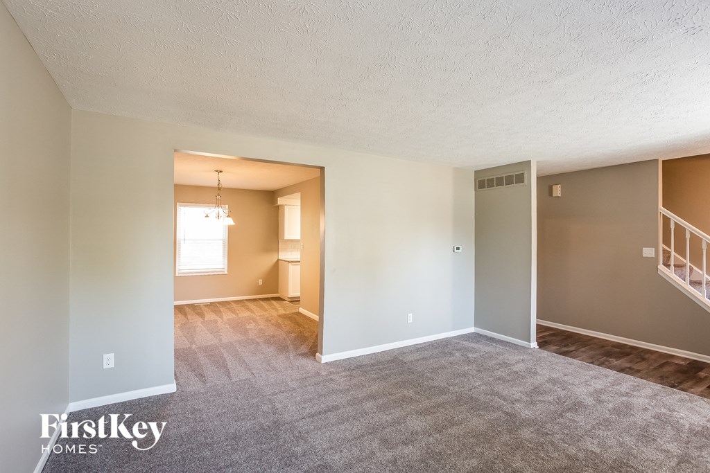 the living room and dining room of an empty house