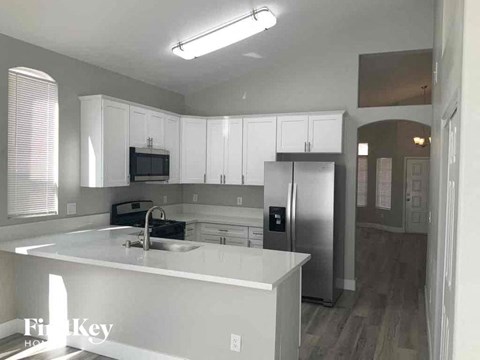A kitchen with a sink, stove, and refrigerator.