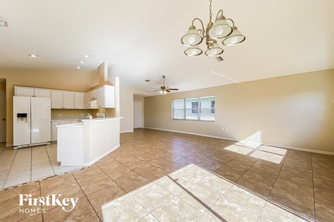 A spacious kitchen with a tile floor and a ceiling fan.