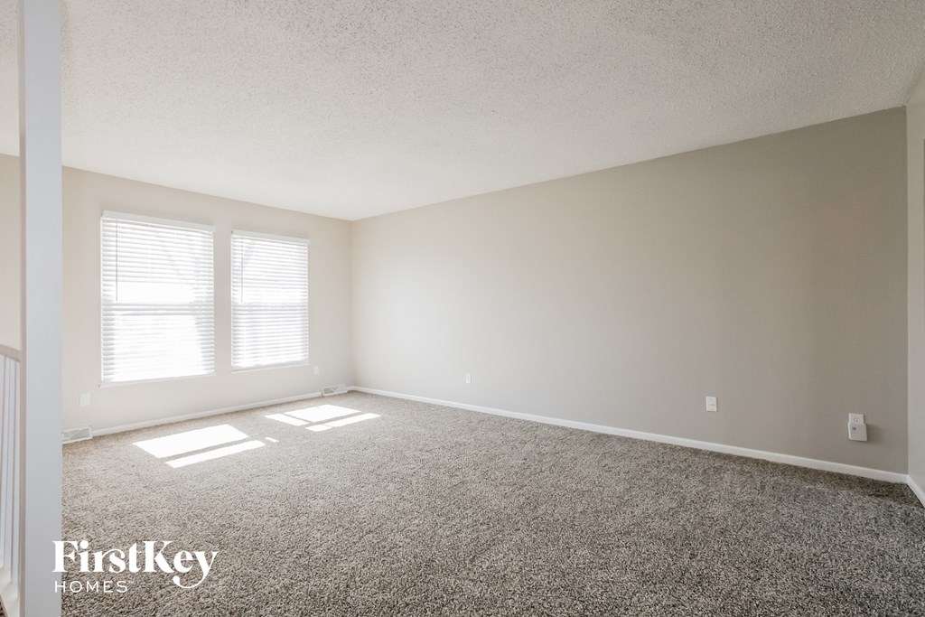 an empty room with carpet and a window