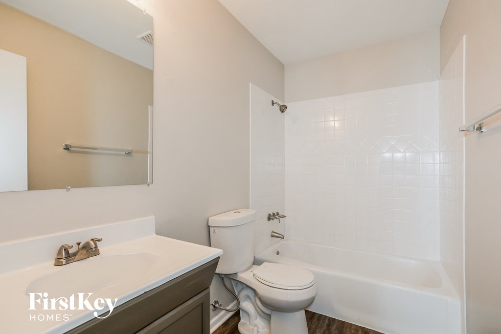 a bathroom with a toilet and a tub and a sink