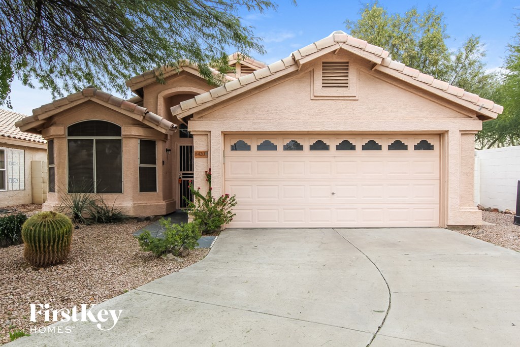 A house with a pinkish facade and a large garage door.