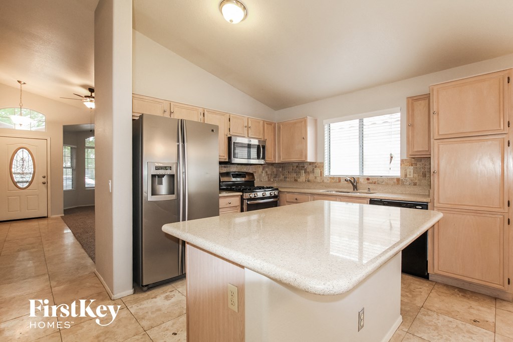 A kitchen with a white counter top and wooden cabinets.