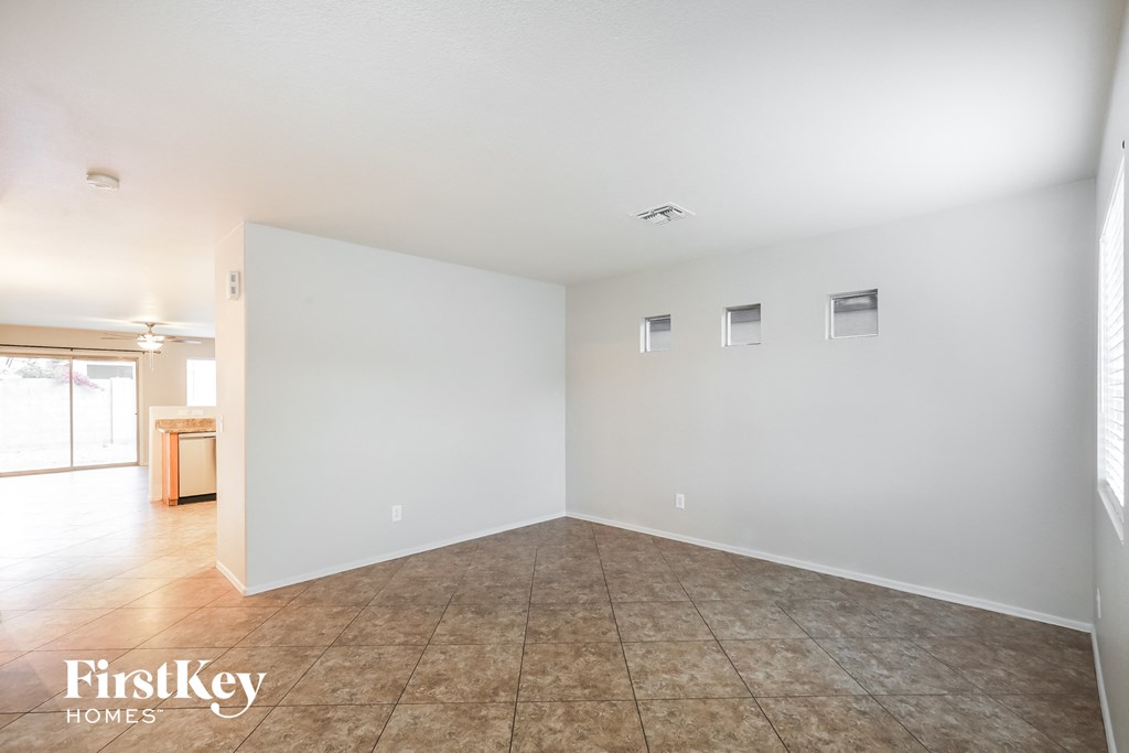 an empty living room with a tile floor and white walls