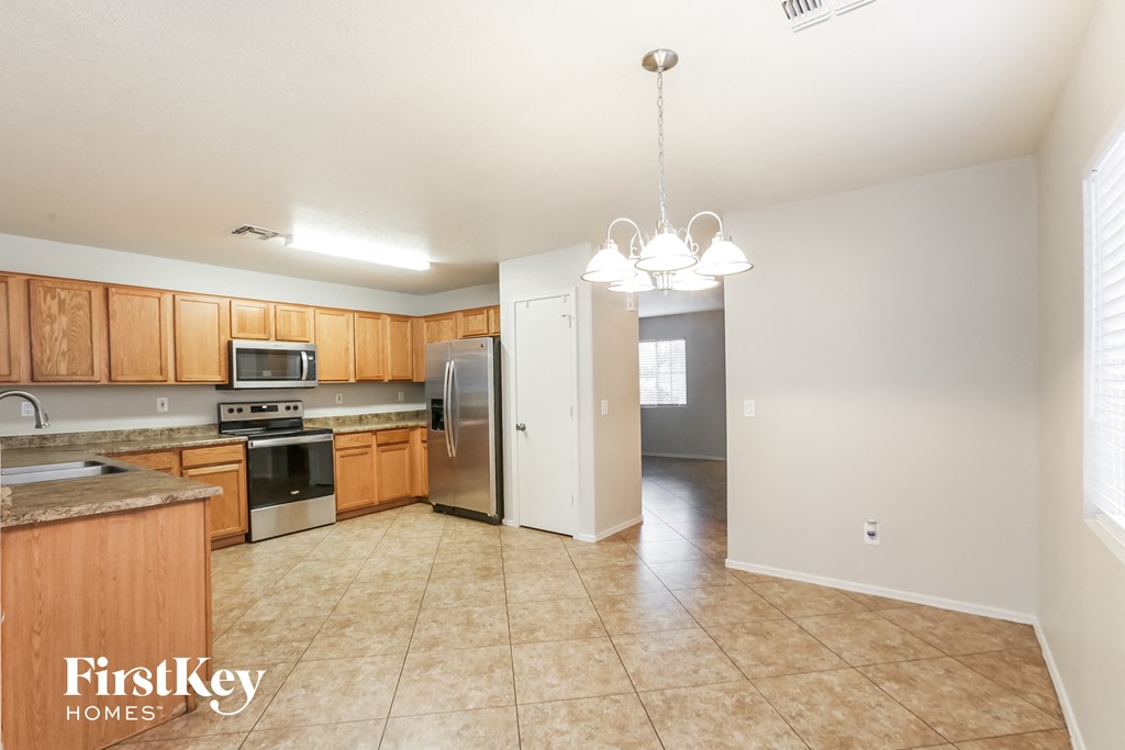 an empty kitchen with wooden cabinets and stainless steel appliances