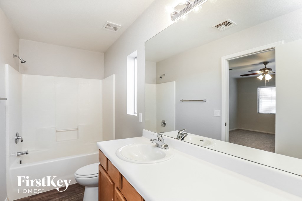 a bathroom with a large mirror and a sink and a toilet