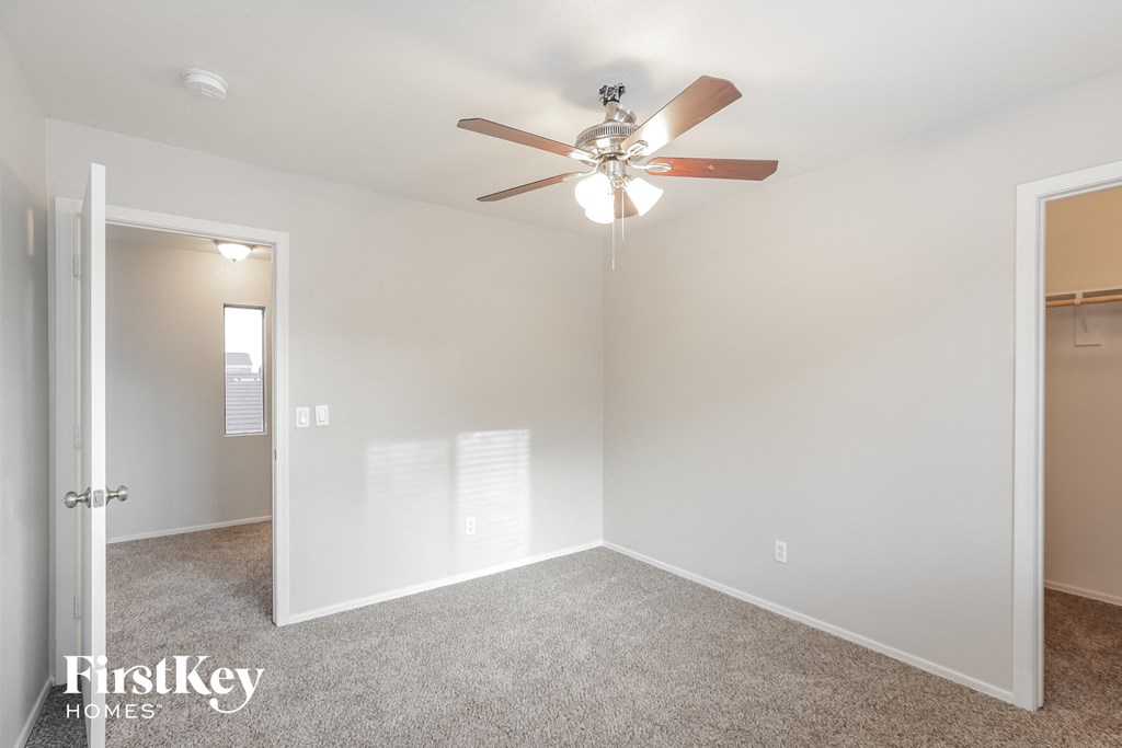 a bedroom with a ceiling fan and a closet