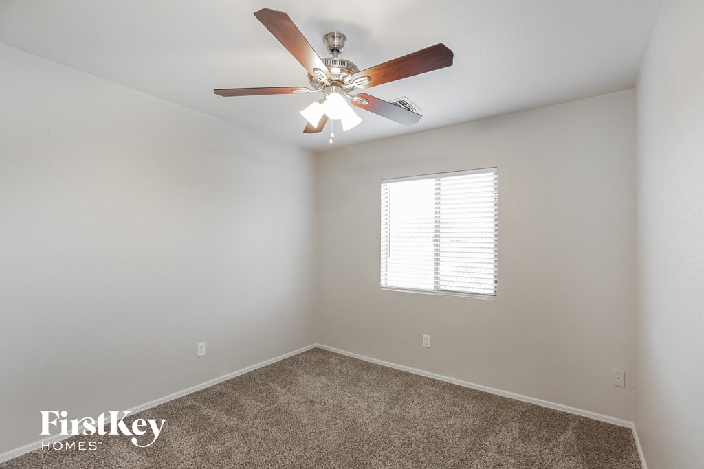 a bedroom with a ceiling fan and a window