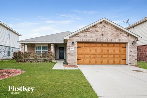 home with a brown garage door on a brick house