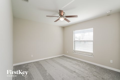 a bedroom with a ceiling fan and a window