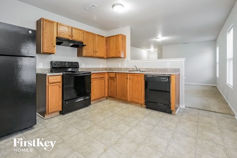 an empty kitchen with black appliances and wooden cabinets