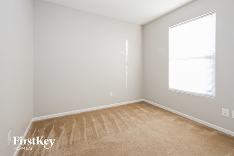 a bedroom with a carpeted floor and a large window