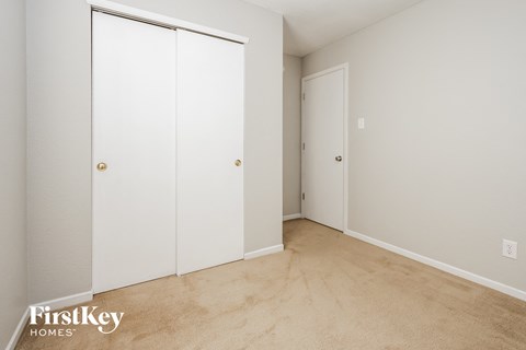 a bedroom with two closets and a carpeted floor
