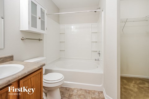a bathroom with a toilet and a tub and a sink