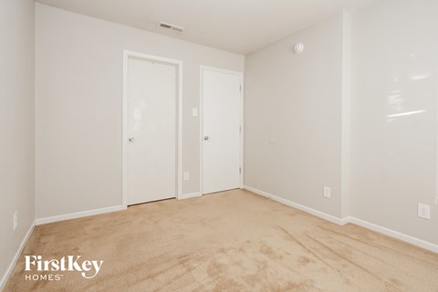 a bedroom with a carpeted floor and white doors