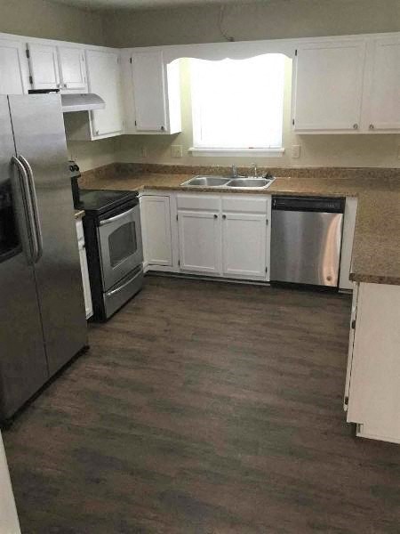 a kitchen with white cabinets and stainless steel appliances