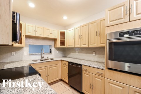 A kitchen with wooden cabinets and a stainless steel oven.