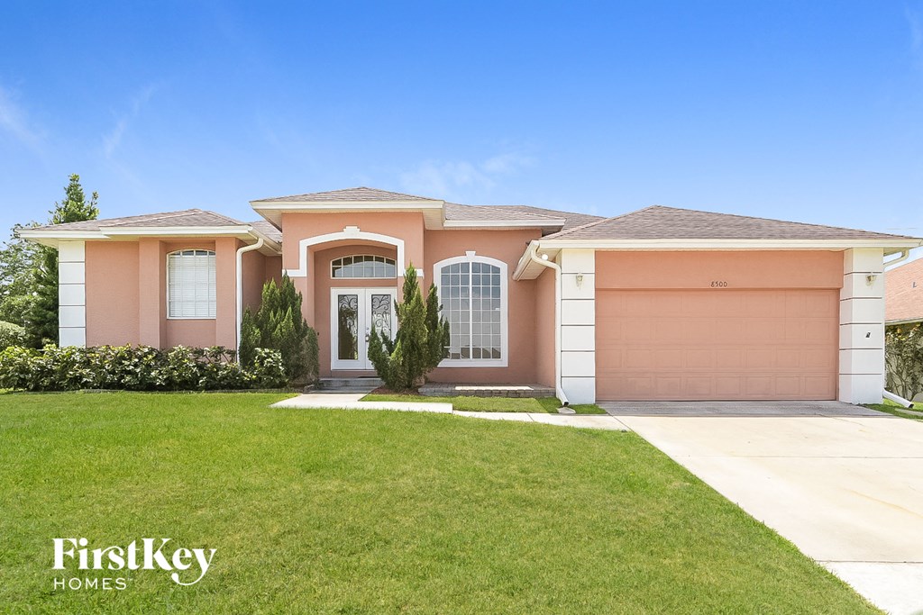a pink house with a lawn in front of it