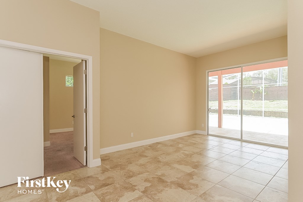 an empty living room with a sliding glass door to a patio