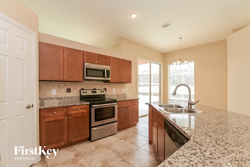 a kitchen with granite counter tops and wooden cabinets