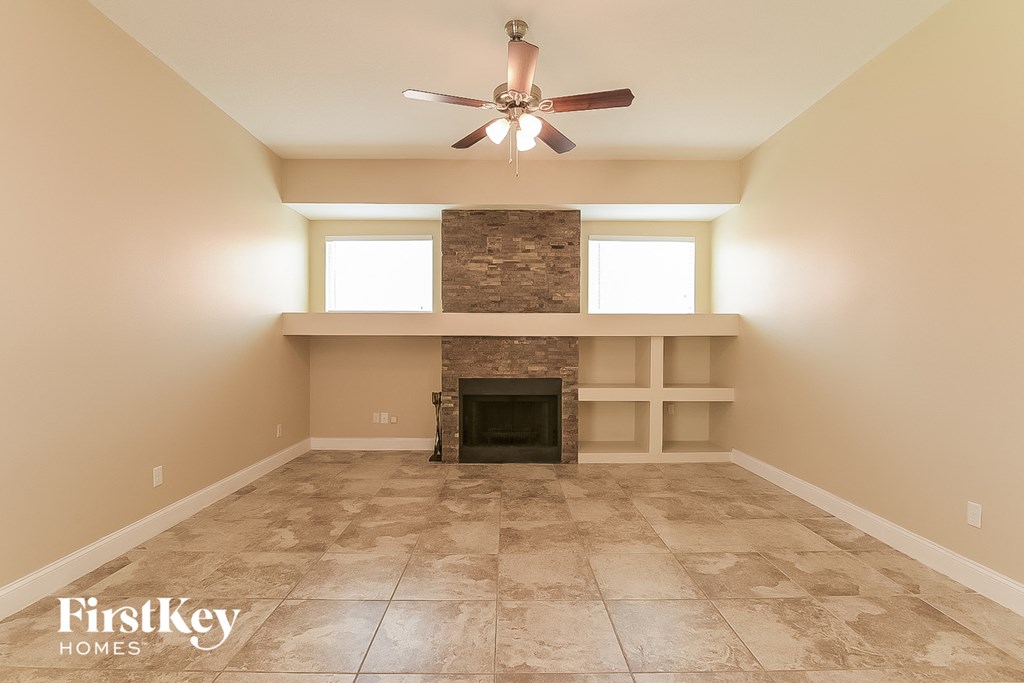 a living room with a fireplace and a ceiling fan