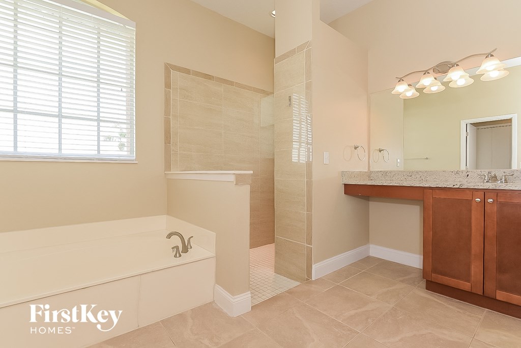 a bathroom with a tub and a shower and a sink