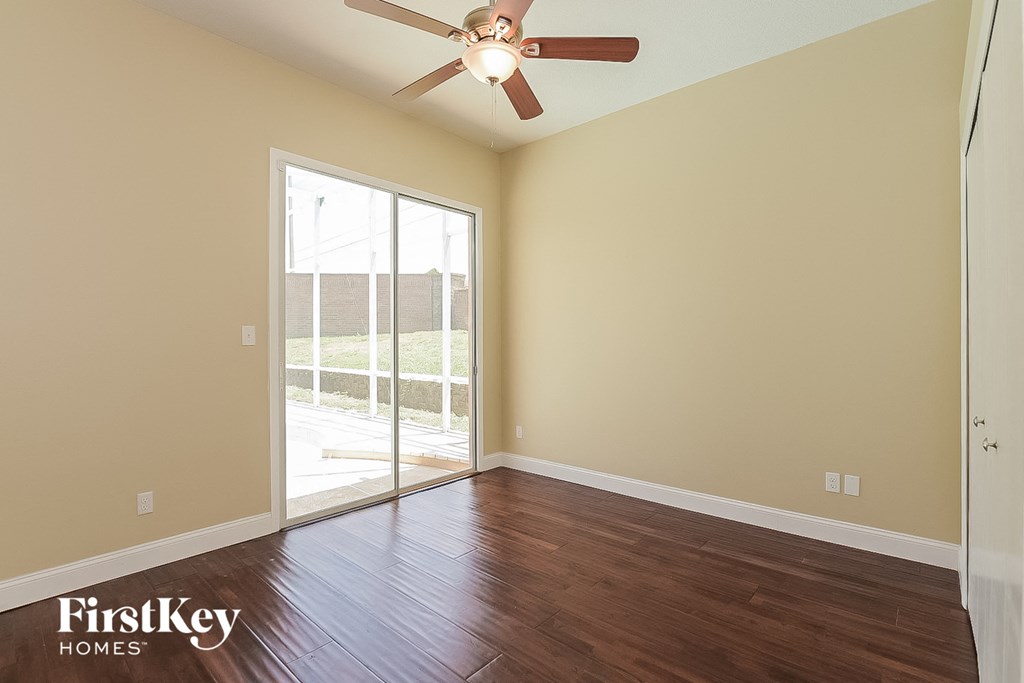 a living room with wood floors and a ceiling fan